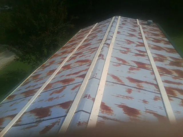 Rusted metal roof panels with new wood purlins before replacement — Storm Damage Roof Repair in Mindoro by Roofing Brothers