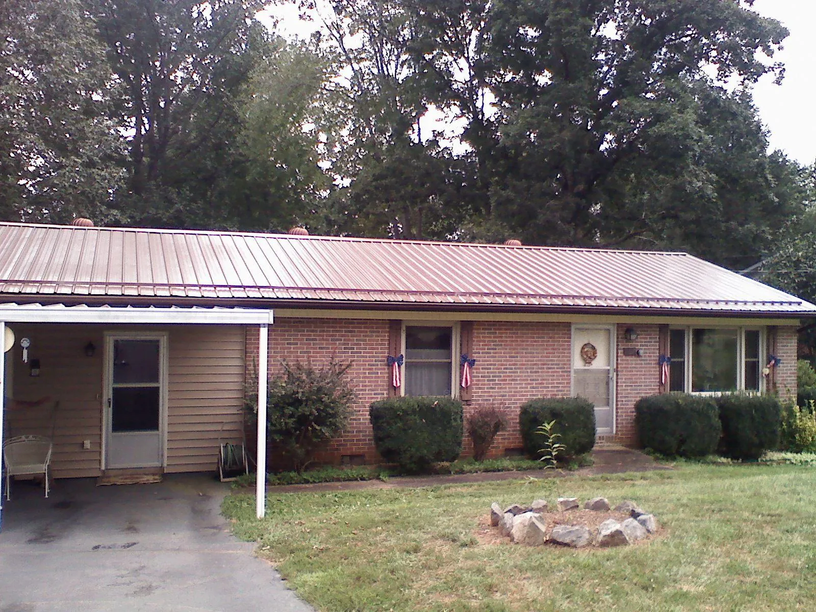 Bronze metal roof and carport on a brick ranch home — Roof Repair work by our crew in Mindoro